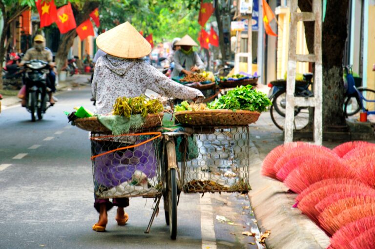 Hanoi in motion. Morning streets, fresh greens, and motorbikes everywhere.