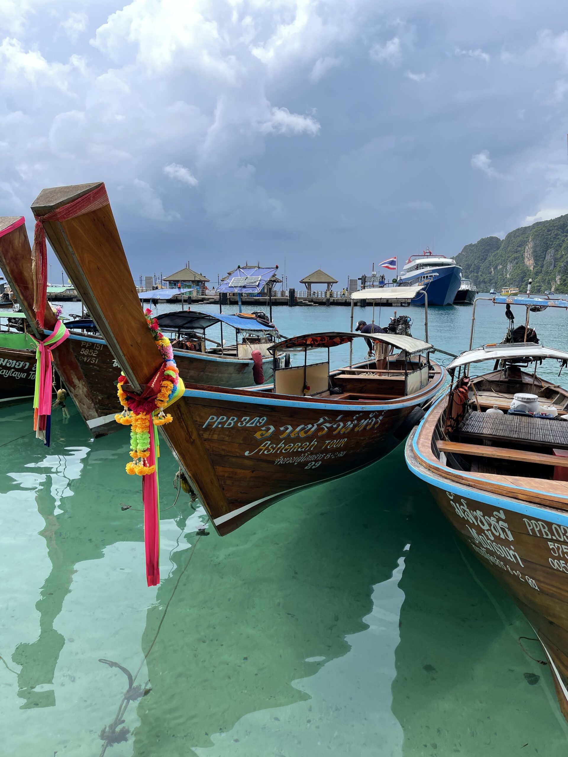 Longtail boats, clear water, and an island day loading.